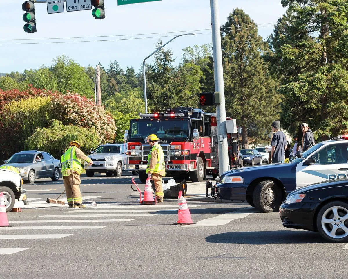 Firefighters and police clearing the scene of a two-car accident at an intersection