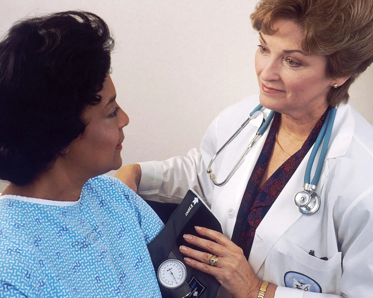 A doctor checking an older woman's blood pressure during a routine visit