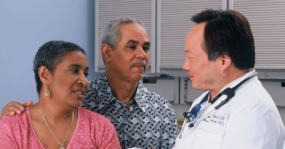A retired couple reviewing health coverage information with a doctor