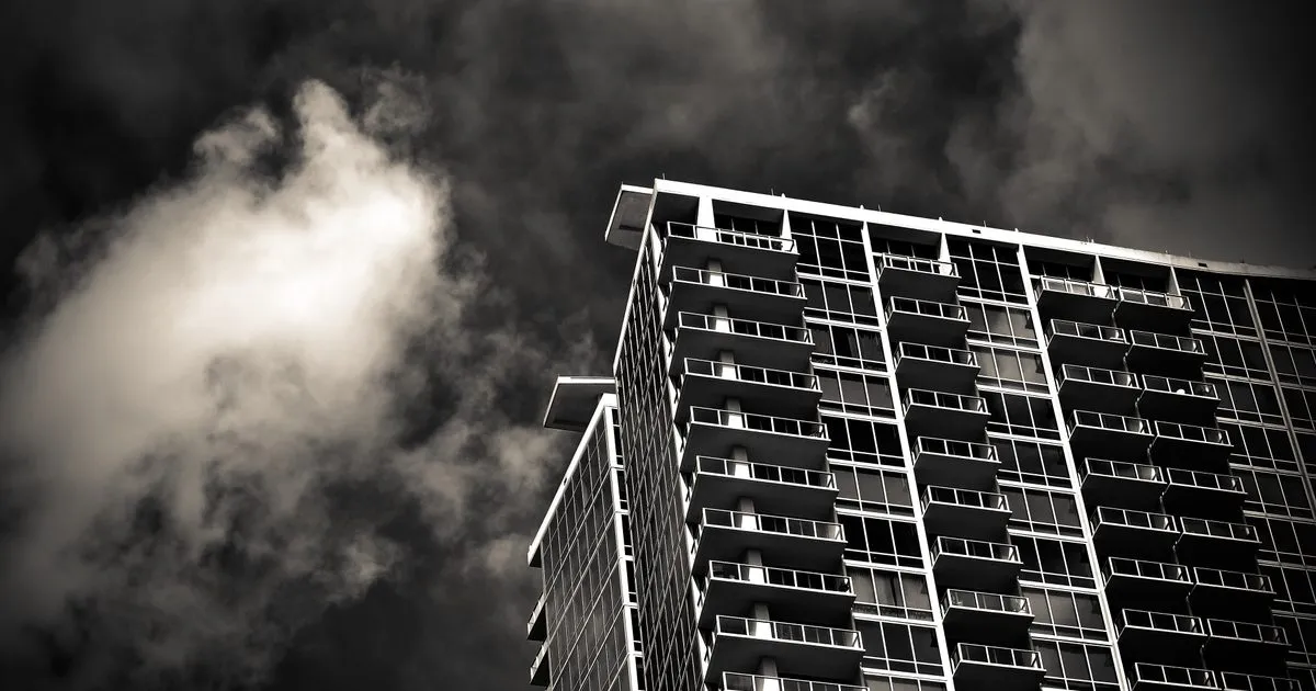 A high-rise apartment tower with balconies under dark storm clouds in Orlando, Florida