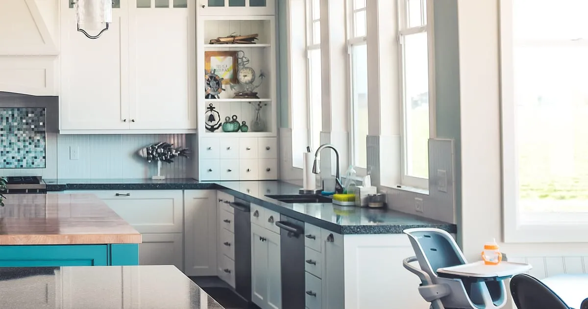 Bright white kitchen with a dishwasher, range, sink and cabinets, the kind of appliances a home warranty covers