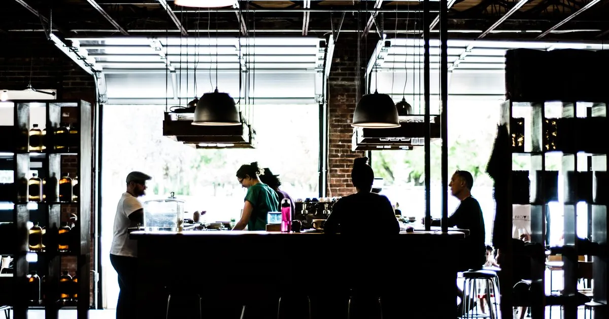 Staff and customers at the counter of a small independent coffee shop