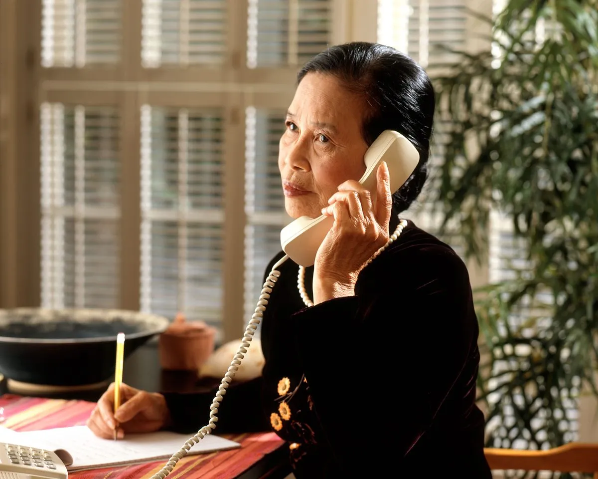 A woman on the phone at her desk, taking notes